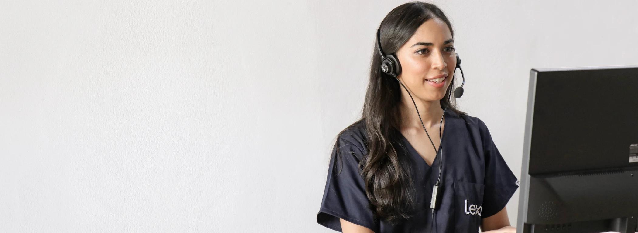 Lexie Expert wearing a headset conducting a call on her desktop.