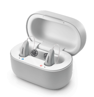 A pair of gray Lexie B2 Powered by Bose hearing aids, inside of a gray case.