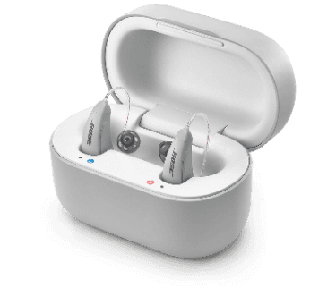 A pair of gray Lexie B2 Powered by Bose hearing aids, inside of a gray case.