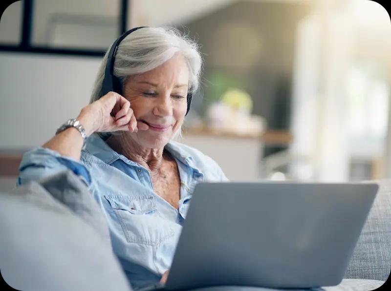 Woman with headphones on looking at something on her laptop