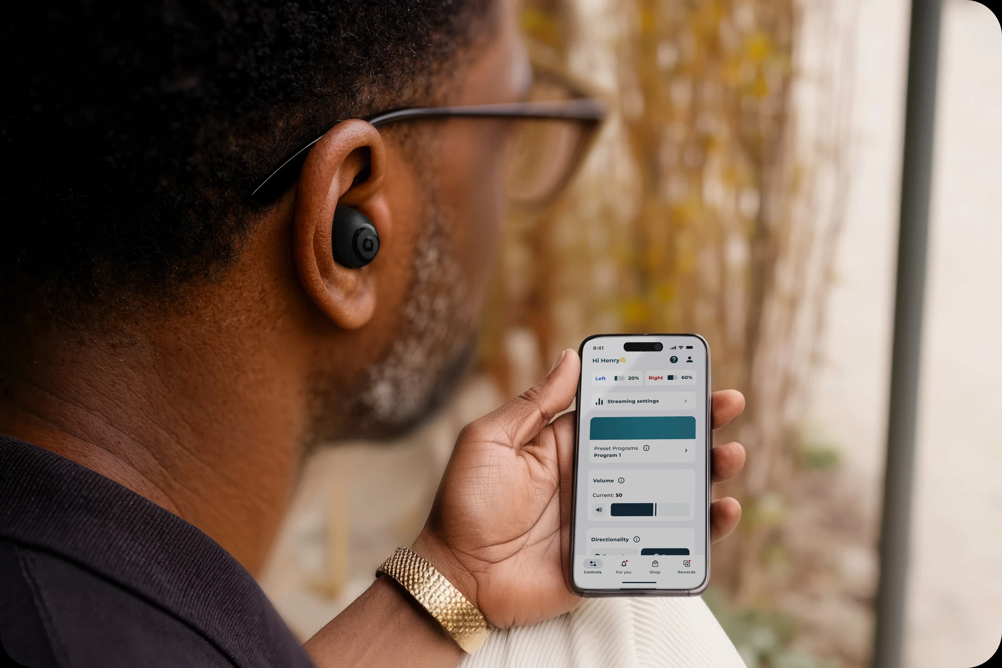 Man adjusting hearing aid settings on a phone