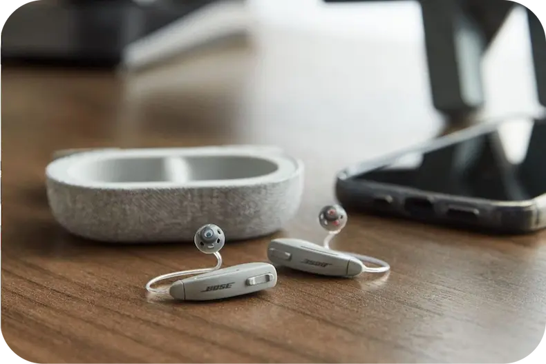 Bose hearing aids next to their case