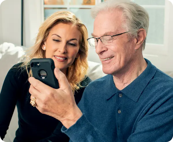 A man on a couch, on his phone, using the Lexie App.