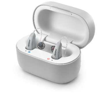 A pair of gray Lexie B2 Powered by Bose hearing aids, inside of a gray case.